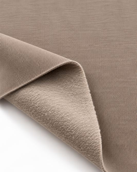 Latte brushed fleece fabric showing a smooth outer surface and soft fleece on the inside.